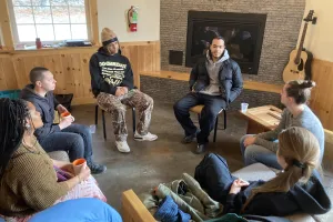 Group of young adults sit in a circle talking